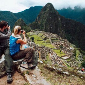 A tourist couple takes pictures of Inca's citadel of Machu Picchu in Cuzco December 2, 2010. Peru will celebrate on July 2011, the first centenary of the discovery of Machu Picchu with a huge exhibition after an agreement with Yale University to return thousands of artifacts taken from the archaeological site in the early 1900s, the Ministry of Culture said on Thursday. REUTERS/Enrique Castro-Mendivil (PERU - Tags: SOCIETY TRAVEL)
